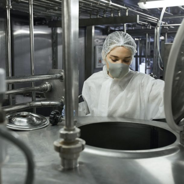 Young Female Worker Controlling Production at Food Factory